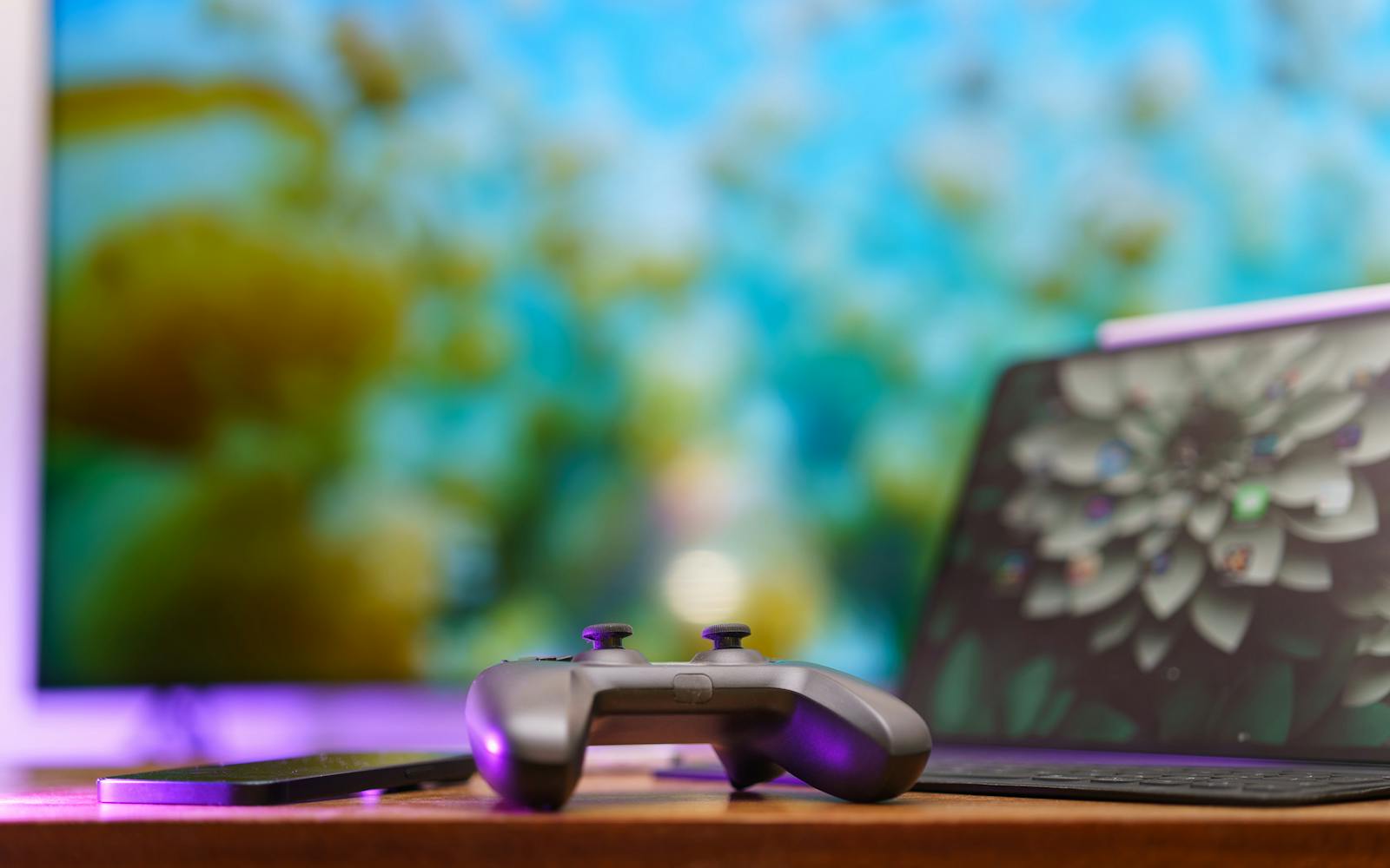 A gaming controller in front of a monitor and laptop, the kind of setup used to broadcast a Madden tournament